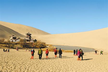 游客在敦煌市鳴沙山月牙泉景區游覽